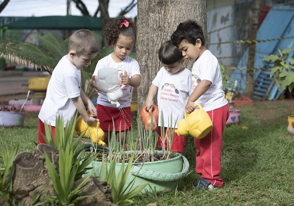 crianças da Educação Infantil regando o jardim 