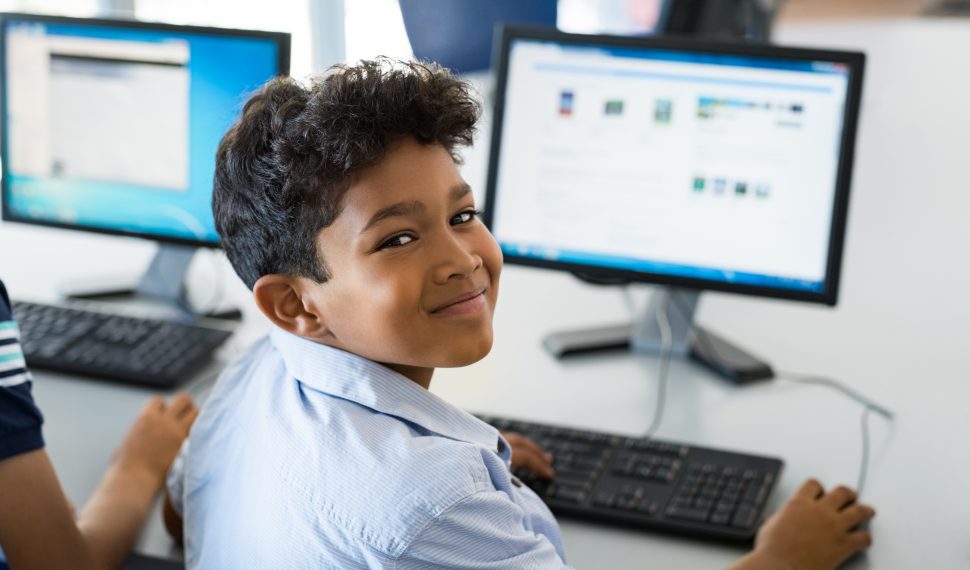 menino feliz usando o computador